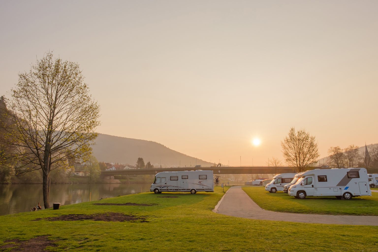 Camping aan het water met geparkeerde campers